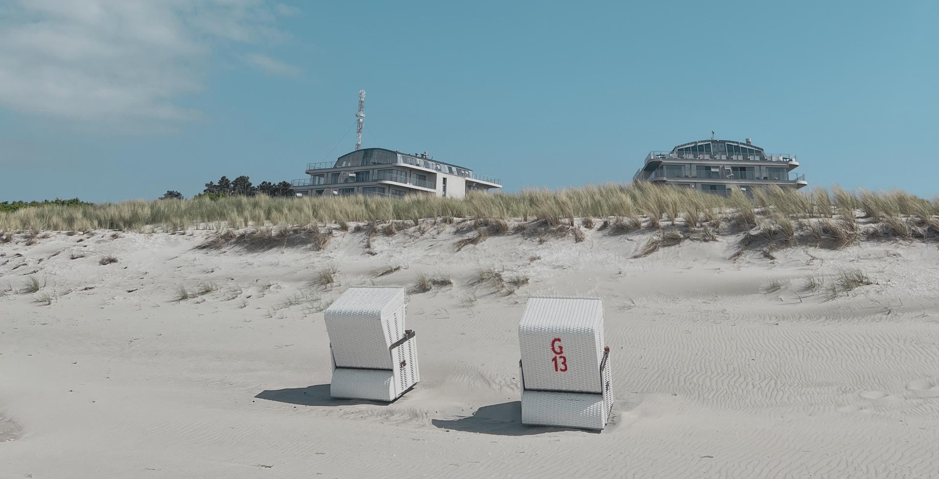 Strandkörbe am Ostseestrand vor den Dünen mit Blick auf THE GRAND Ahrenshoop.