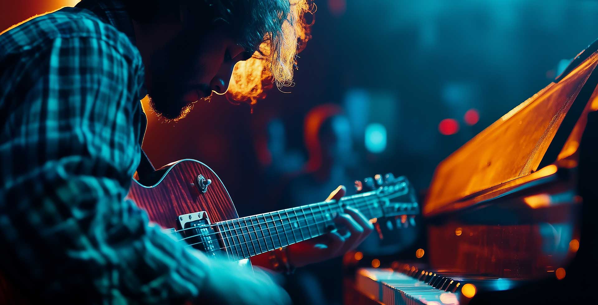 Musiker spielt Gitarre in warmem Bühnenlicht, im Hintergrund Publikum – stimmungsvolle Atmosphäre beim Charity Wohnzimmerkonzert im THE GRAND.