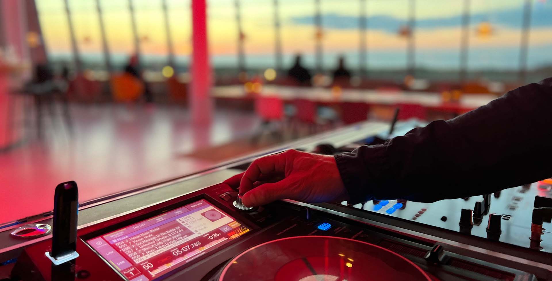 DJ Pult in der Lounge im THE GRAND Ahrenshoop mit Blick auf die Ostsee bei Sonnenuntergang.