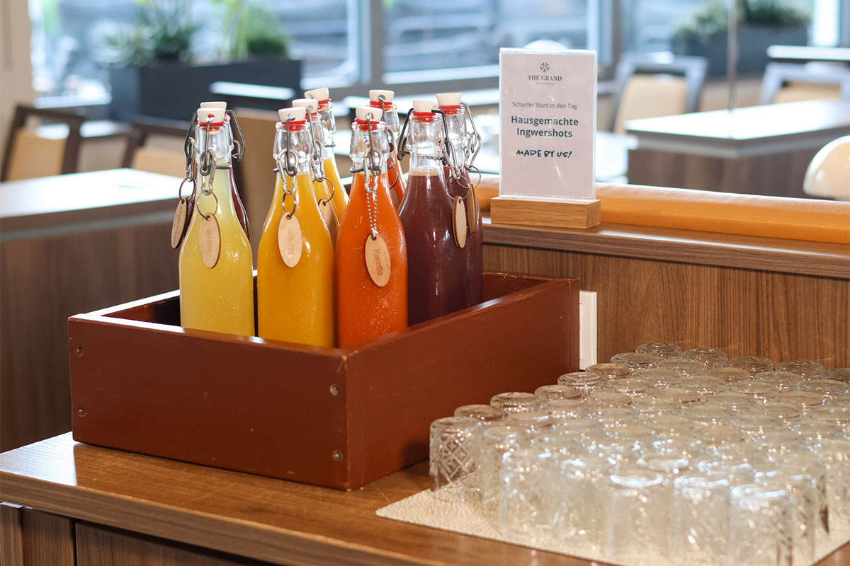 Hausgemachte Ingwershots in Glasflaschen am Frühstücksbuffet an der Ostsee.