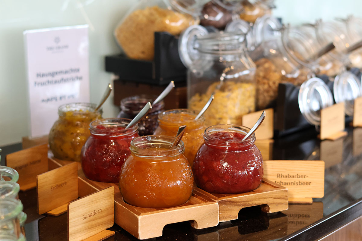 Mehrere Gläser mit hausgemachten Fruchtaufstrichen stehen am Frühstücksbuffet an der Ostsee.