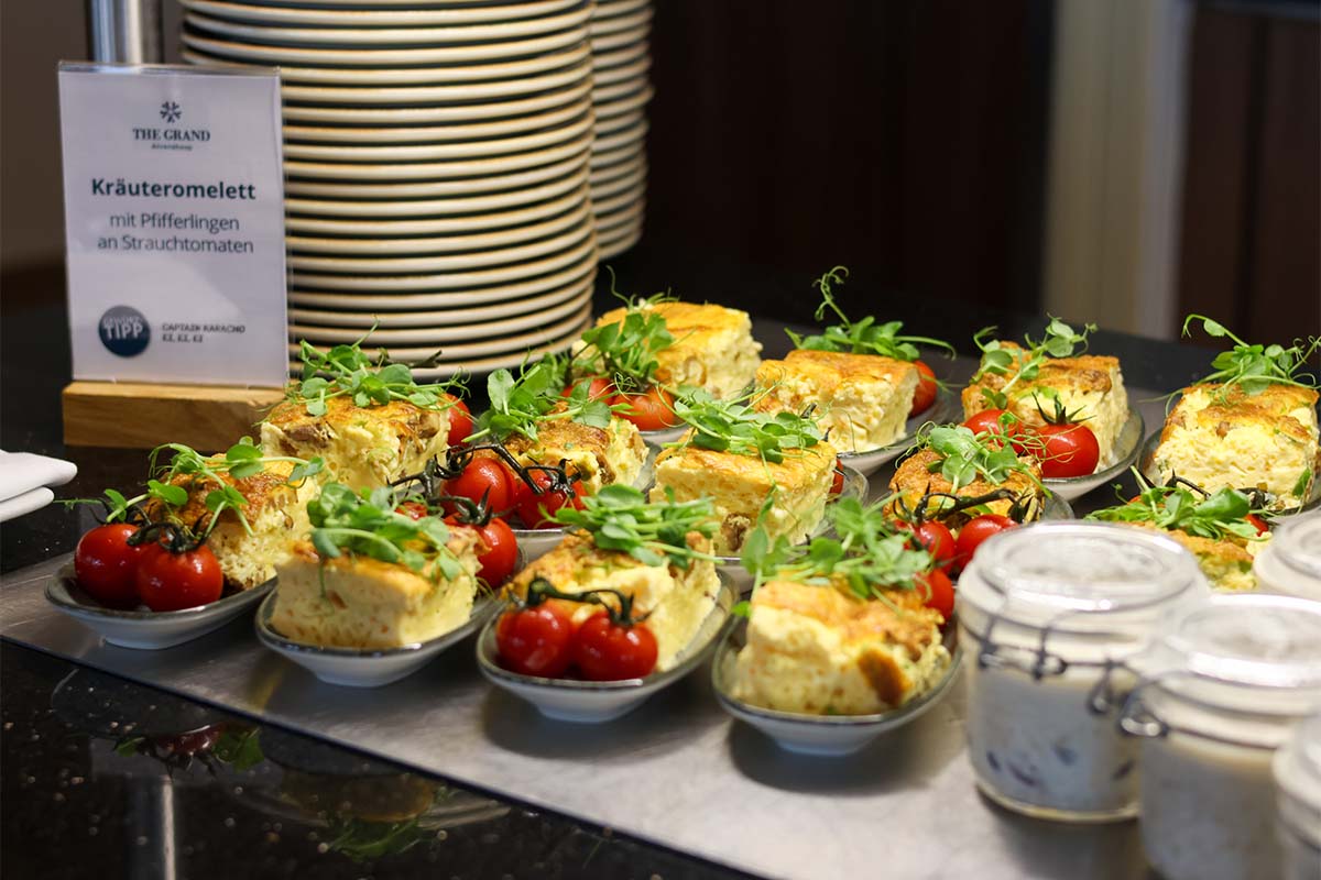 Portionierte Kräuteromeletts mit Pfifferlingen und Cherrytomaten stehen am Frühstücksbuffet an der Ostsee.