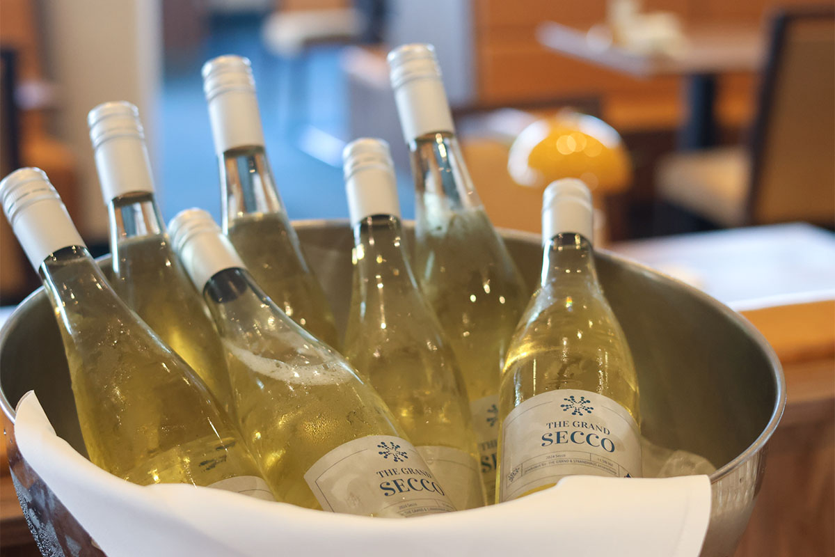Mehrere gekühlte Secco Flaschen liegen in einem Eisbehälter im THE GRAND Ahrenshoop.