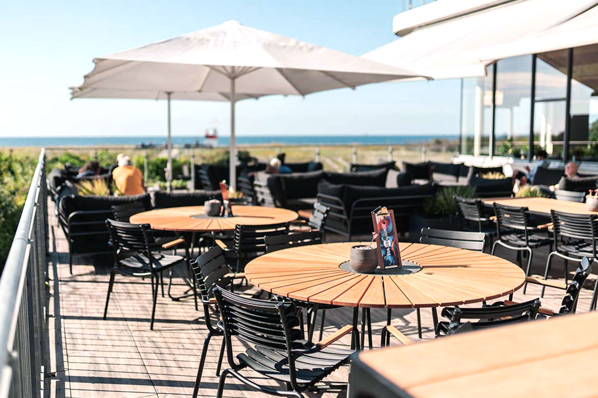 Außenterrasse des SEASIDE Restaurants mit Tischen und Blick auf die Ostsee in Ahrenshoop.