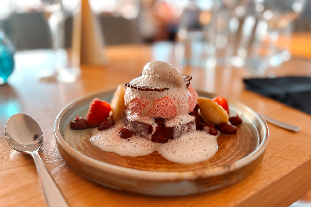 Dessert mit Erdbeeren, Creme und Schaum wird im Restaurant WEITBLICK in Ahrenshoop serviert.