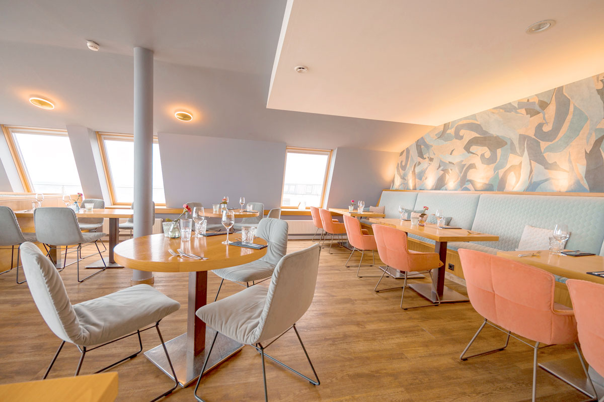 Heller Gastraum mit gedeckten Tischen im Restaurant WEITBLICK in Ahrenshoop.