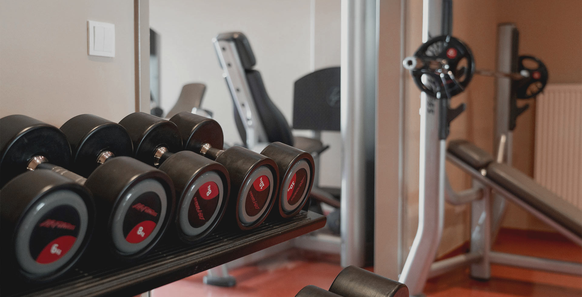Hantelbank mit Kurzhanteln und Kraftgerät im Fitnessstudio an der Ostsee.