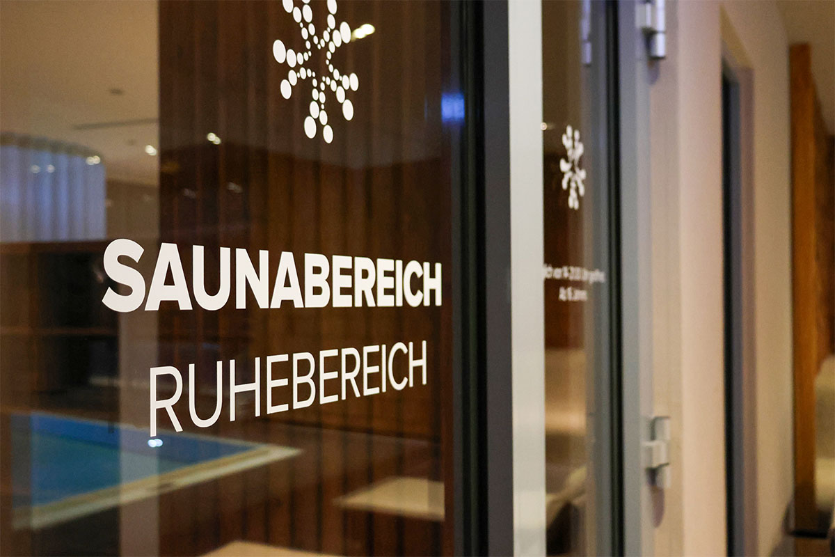 Glastür mit der Aufschrift Saunabereich und Ruhebereich im Spa des THE GRAND Ahrenshoop an der Ostsee.